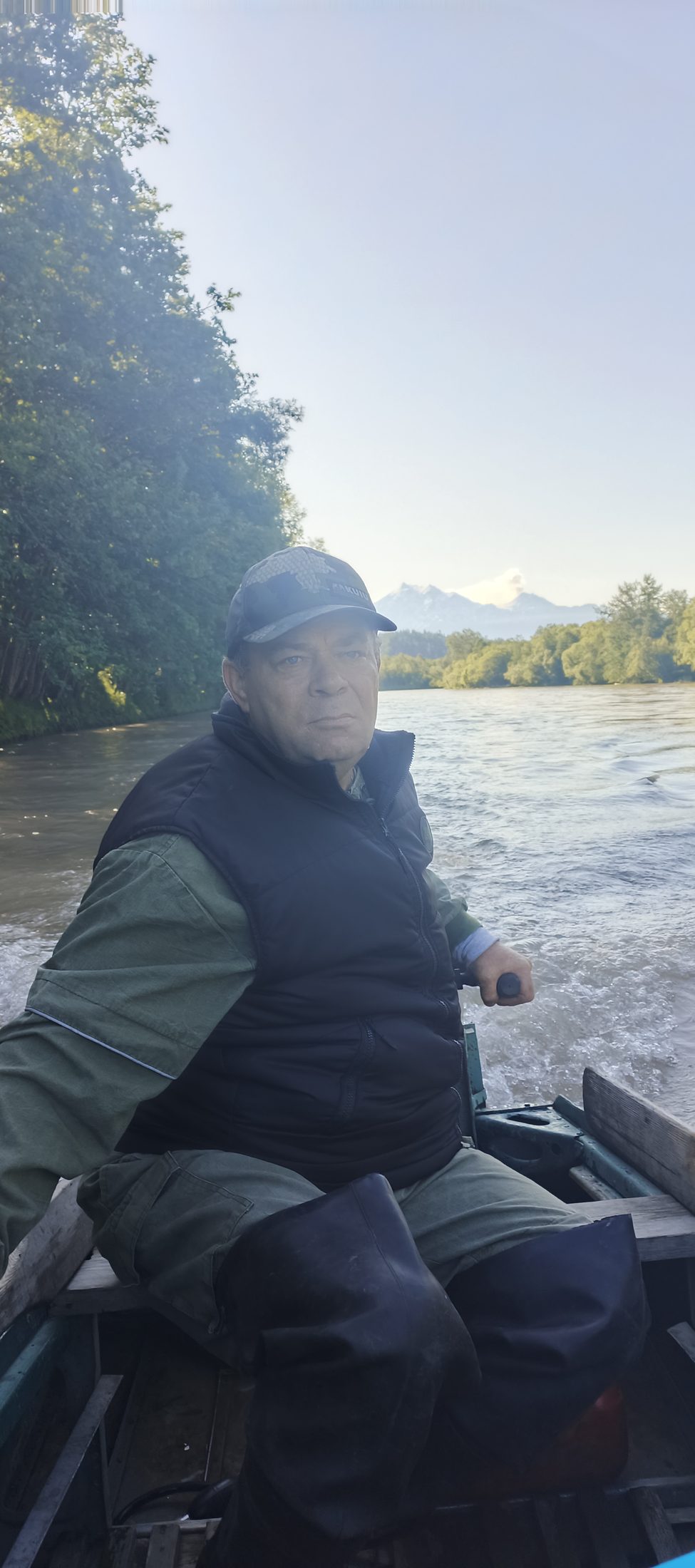 Владимир на лодке, за спиной вулкан